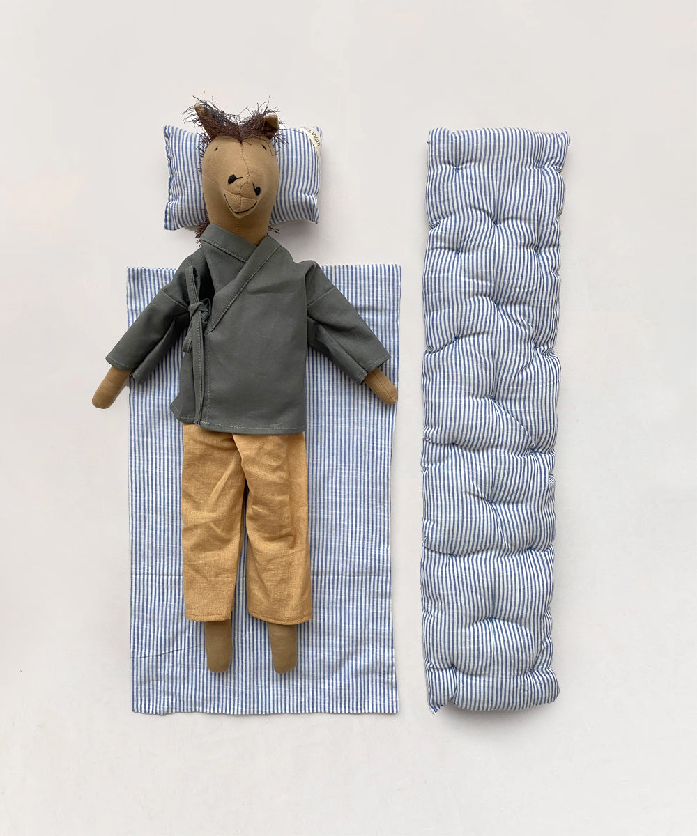 A Le Horsey fabric doll, in a green top and tan pants, rests on a striped mat with a matching pillow. A rolled striped mattress lies beside it.