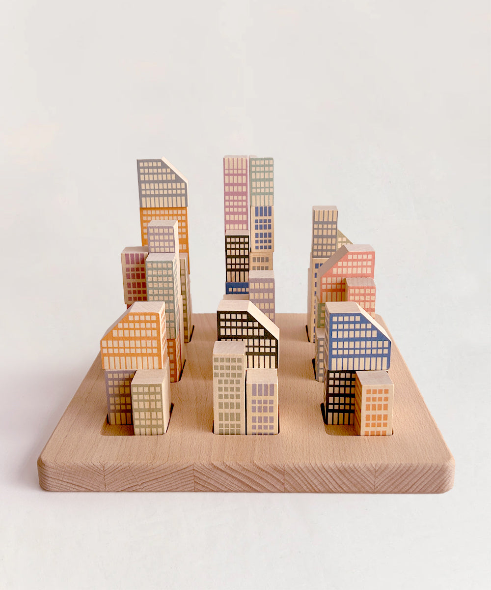 The Le Manhattan Skyline Blocks resemble a small city skyline arranged on a wooden base.