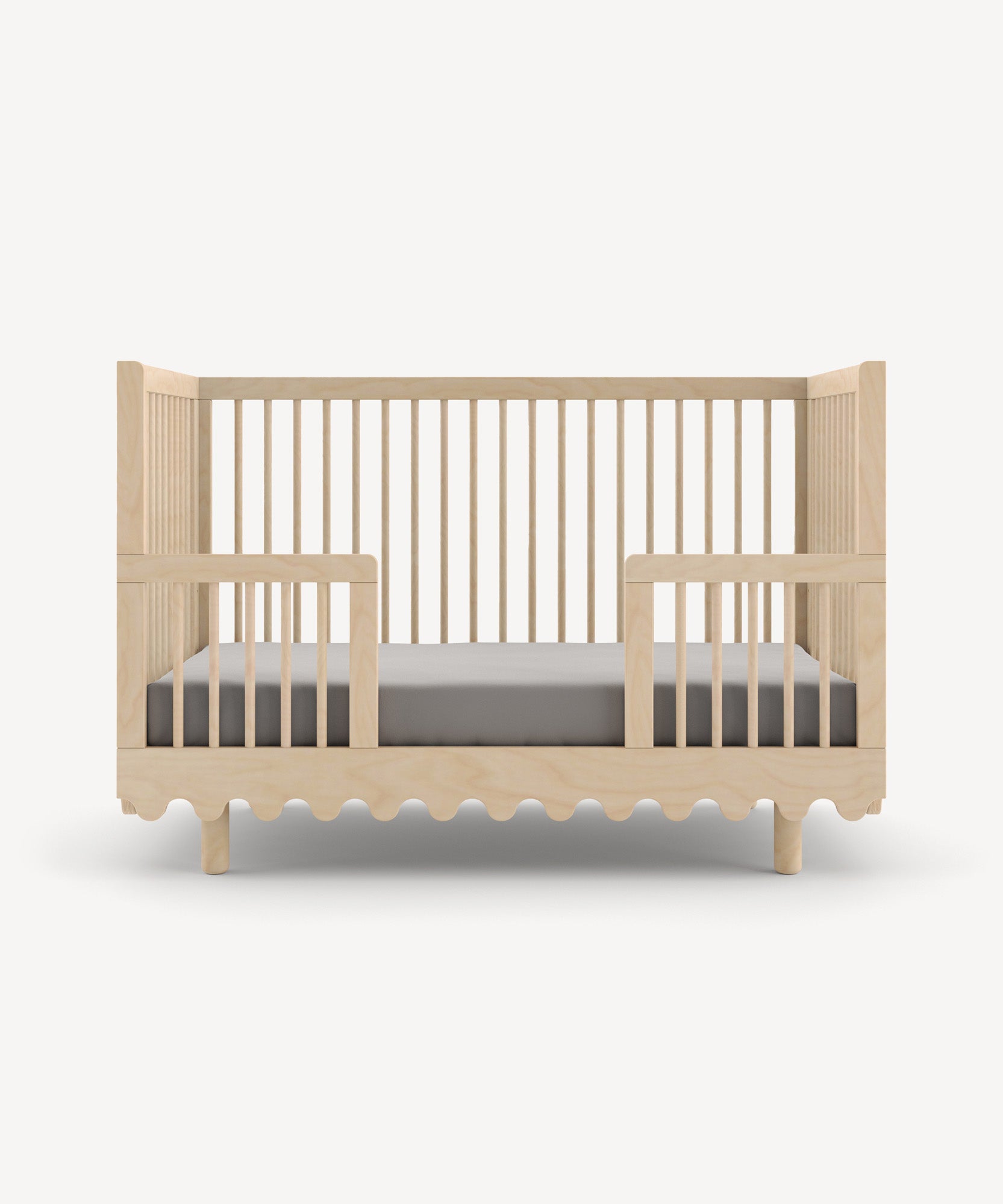 Moss Crib Conversion Kit with slatted sides, a wavy base design, and comes with a gray mattress.