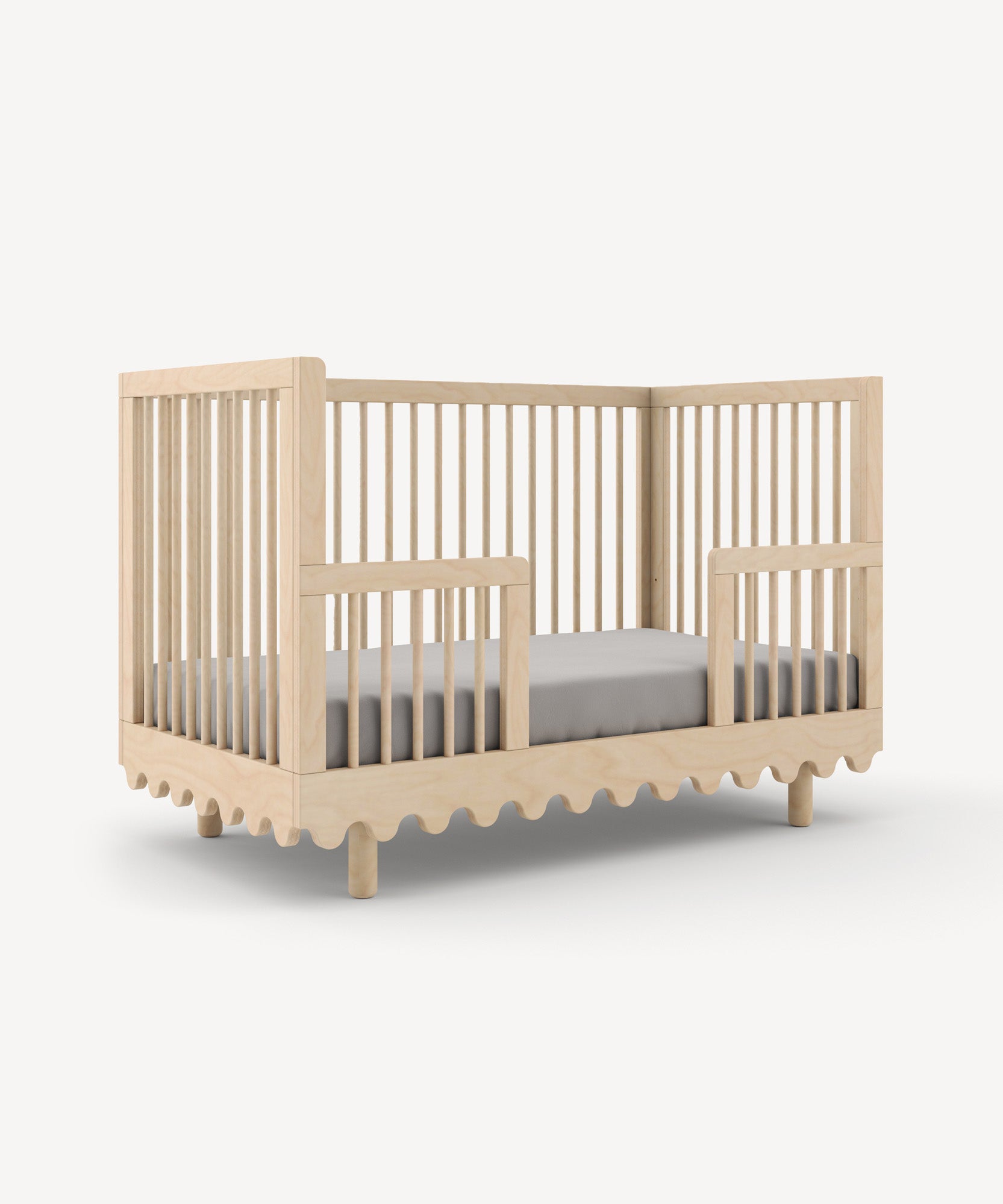 Moss Crib Conversion Kit in a light finish with slatted sides and wavy bottom edges set against a plain background.