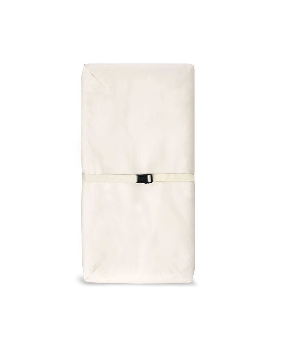 A folded Naturepedic 4-Sided Changing Pad in off-white, secured with a black strap, on a white background.