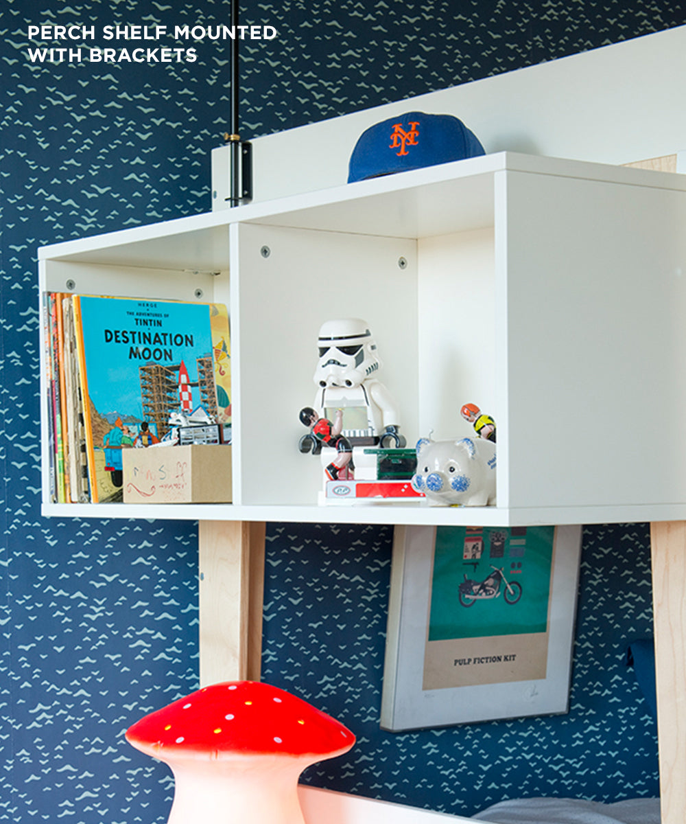 The Perch Shelf - Twin Size holds books, a Stormtrooper, toys, and a New York Mets cap against a patterned blue wall.