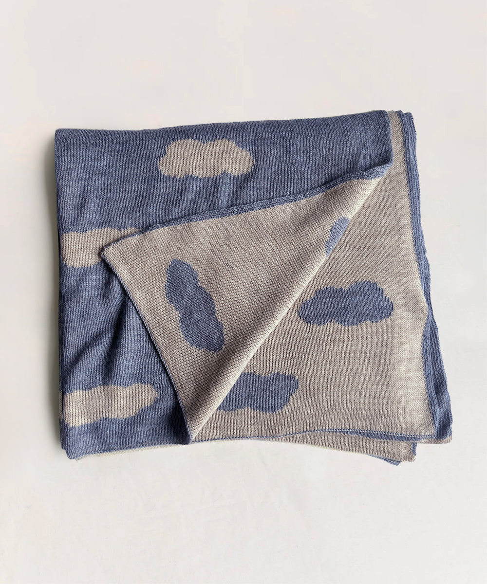 Cloud Blanket: Folded, featuring blue and gray cloud patterns on a light background.