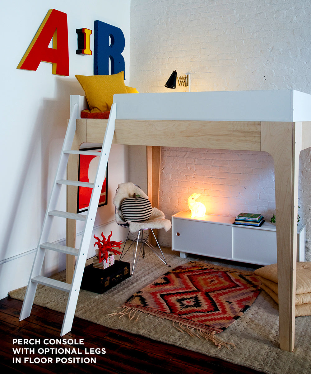 The setup includes a Perch Console - Full Size with ladder, vibrant wall letters, a cozy rug, and decorative lighting for a modern and playful room ambiance.