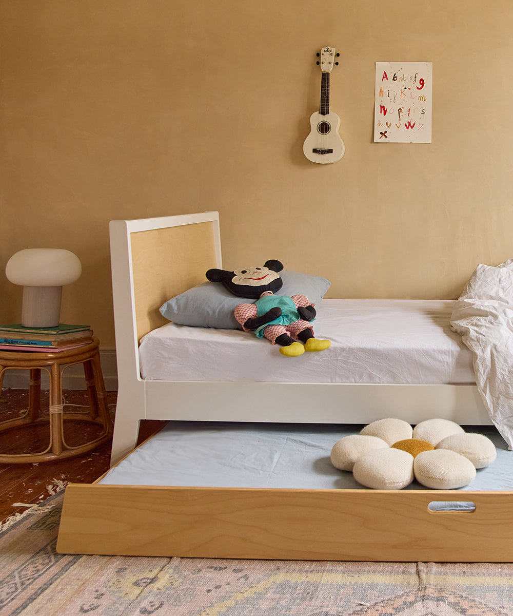 Cozy childrens bedroom featuring a Sparrow Twin Bed, plush toys, a guitar on the wall, and a decorative rug on the wooden floor.