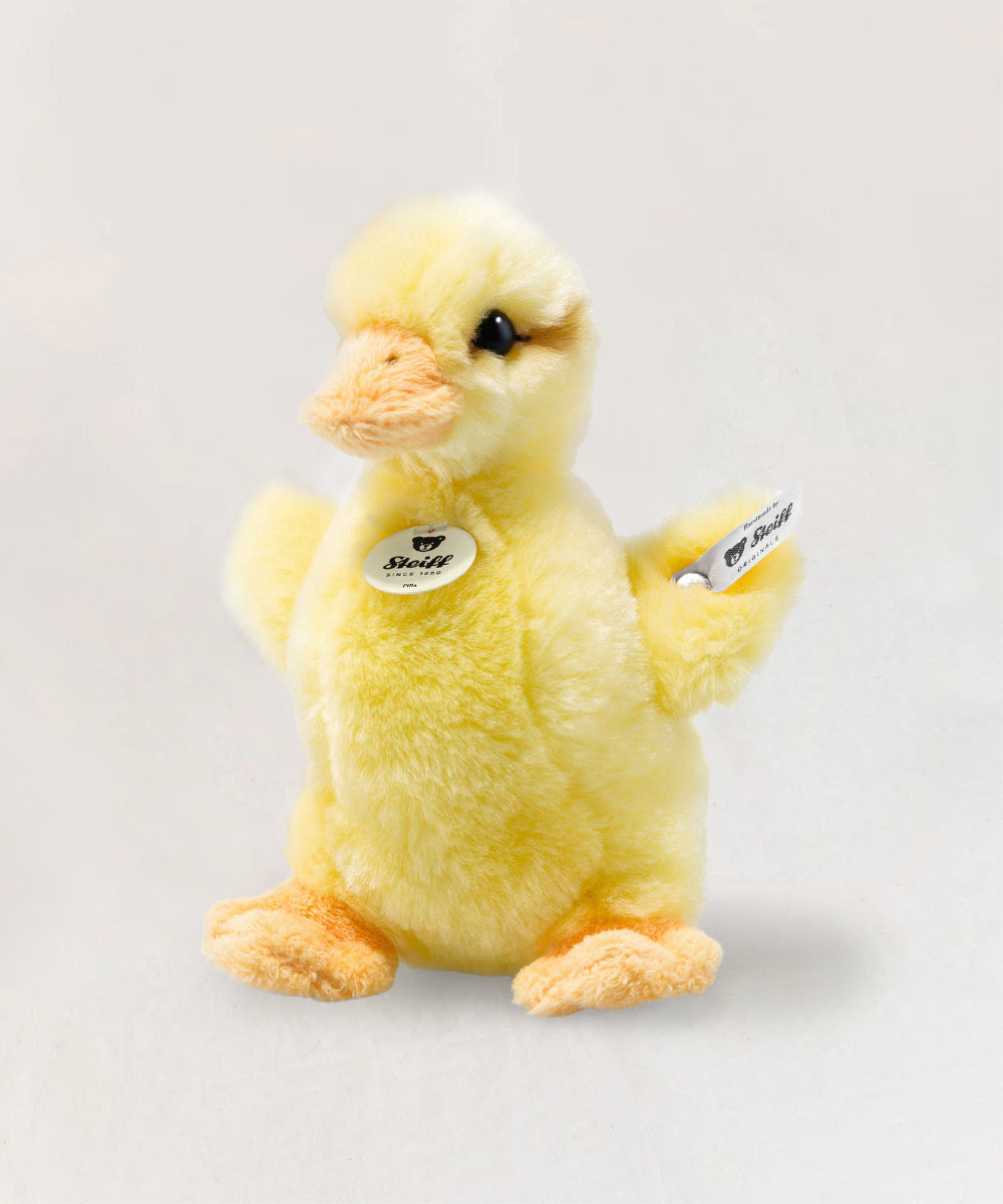 A plush yellow Le Duckling toy with an orange beak and feet, featuring a Steiff tag on its side.